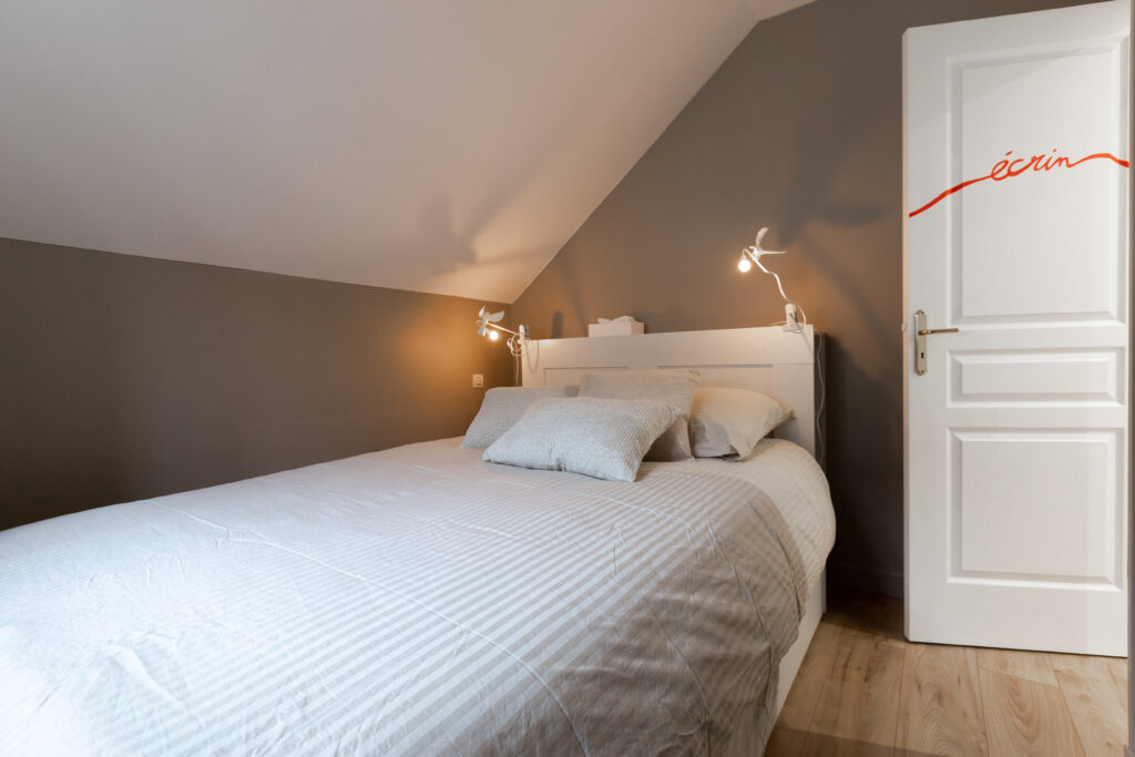 Une chambre pensée comme un écrin, où les textiles absorbent la lumière et apaisent l’espace.
