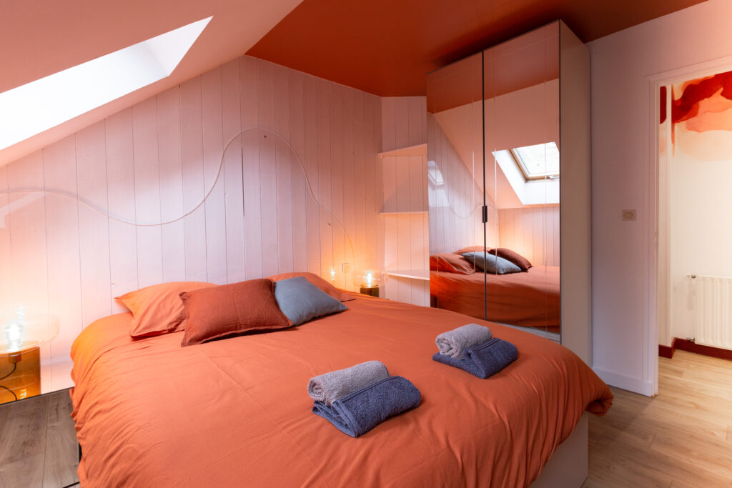 Chambre sous pente du gîte Le Rubis, projet d’architecture d’intérieur à Bayeux avec lumière douce et matières brillantes